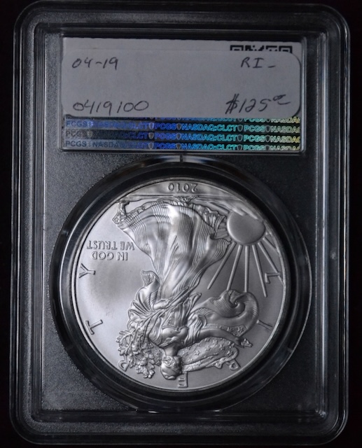 2010 Silver Eagle dollar coin strike-through error showing impression of foreign material in the coin surface struck between die and planchet during minting